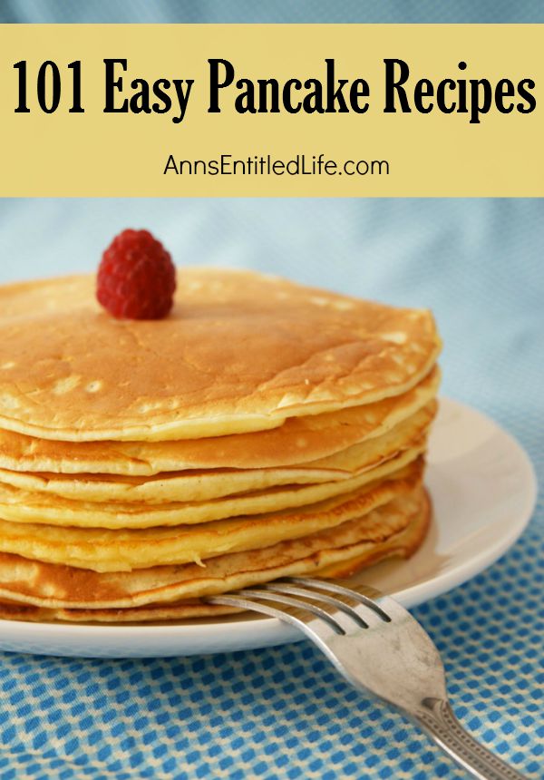 a stack of buttermilk pancakes on a white plate, a raspberry tops the stack. The dish is set on a blue and white dishcloth.