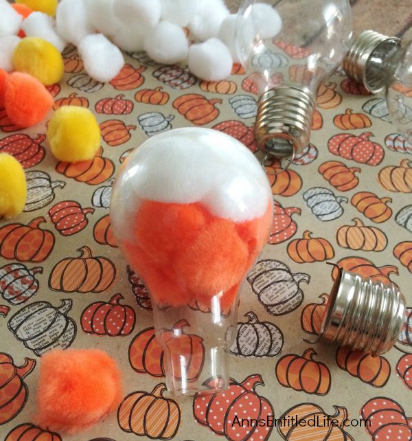 Candy Corn Light Bulb Craft; this super cute candy corn light bulb craft that is easy enough for a child to make (with adult supervision). These candy corn light bulbs can be strung on a ribbon as a banner, hung in a window as décor, or set up in on your table on a dish or nestled in popcorn as a centerpiece!