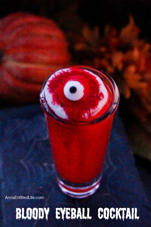 one red cocktail make up to look like bloody eyeballs, against a dark background