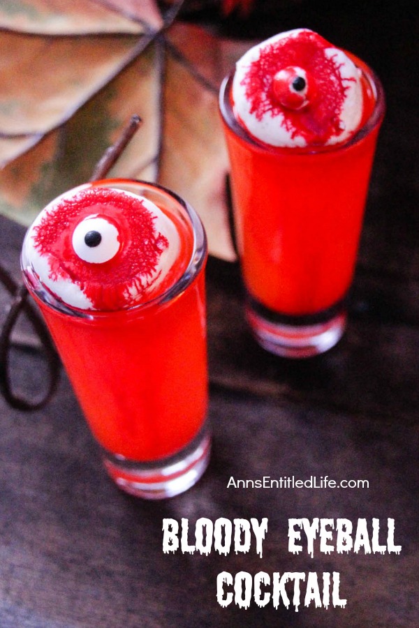 two red cocktails make up to look like bloody eyeballs, against a dark background