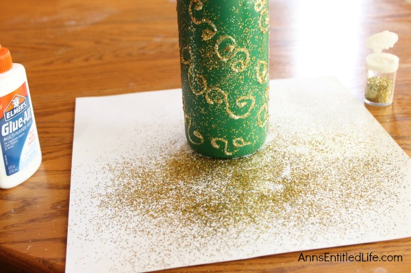 Easy DIY Wine Bottle Christmas Tree. An empty wine bottle, some glitter, paint and glue combined with a little imagination easily transforms into a pretty holiday decoration! Upcycle your empty wine bottles to make a lovely Christmas Tree decoration. Make one or make a grouping to form a centerpiece, mantel decoration, or unique side table decor.