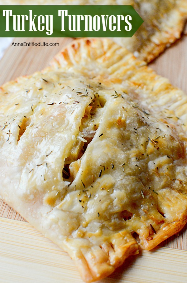 A large turkey turnover sits at the forefront on a cuttingboard. There is a second turkey turnover above it