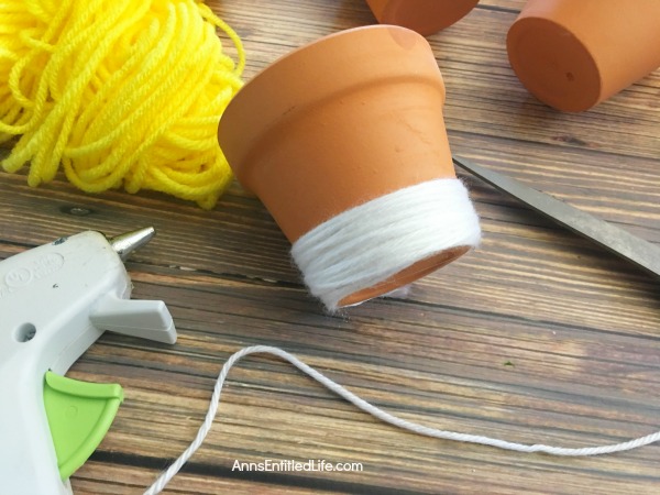 DIY Candy Corn Pots. These DIY Candy Corn Pots are simple to make. Dress up your pots for autumn or Halloween with this sweet candy corn decoration. Perfect for planting herbs in the fall for your kitchen window, or to hold candy corn candy, Halloween treats or nuts on a sideboard, mantel or end table, these do it yourself candy corn posts are a nice touch of whimsical fall décor.