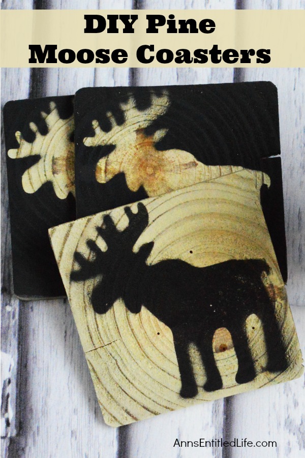 Close-up of a three pine coasters stamped with a moose image.