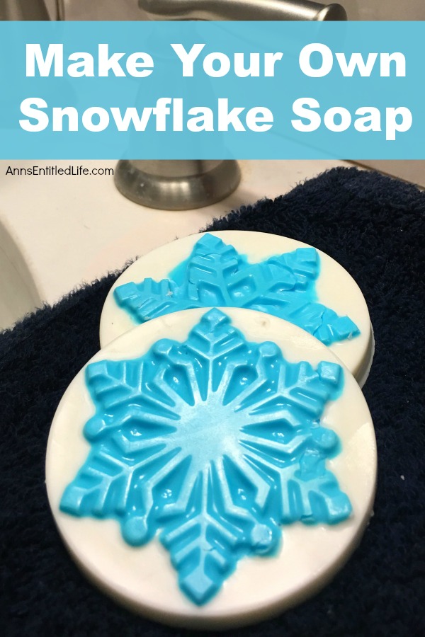 Two round white soap with a blue snowflake in the center (part of the soap) on top of a dark sink counter.