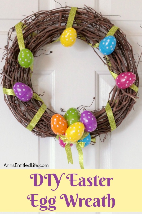 a grapevine Easter wreath decorated with eggs and ribbon hanging against a white door