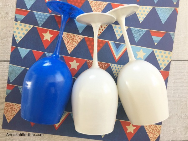 Flag Wineglass DIY. Make your own unique patriotic flag wineglasses! This easy step by step tutorial will show you how to easily make flag wineglass decor which are perfect for a centerpiece, mantel decor or table decorations. This is an easy to make craft project.