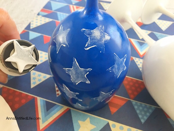 Flag Wineglass DIY. Make your own unique patriotic flag wineglasses! This easy step by step tutorial will show you how to easily make flag wineglass decor which are perfect for a centerpiece, mantel decor or table decorations. This is an easy to make craft project.