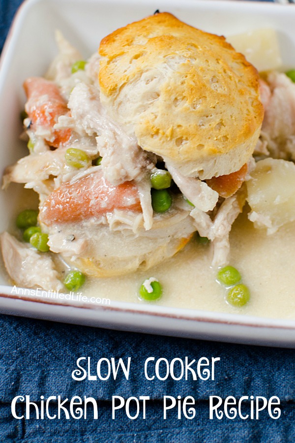 A close-up of servings of slow cooker chicken pot pie in a biscuit, served in a white bowl with a red line detail, on a blue placemat.