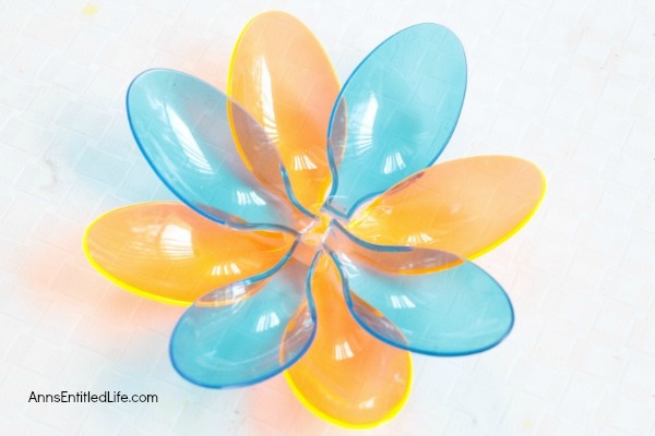 DIY Floating Spoon Flowers. Make your own floating flowers from plastic spoons! These simple to make floating flowers would be perfect to use at a wedding, summer party, in a backyard pool, or to light up in your backyard pond.