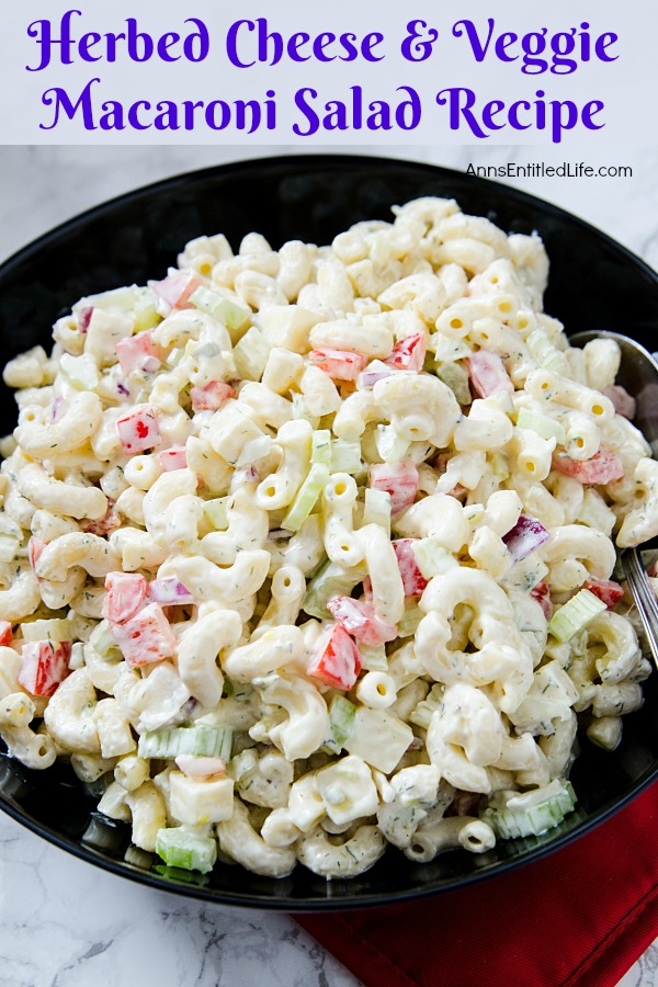 a close-up of herbed cheese and veggie macaroni salad in a black bowl