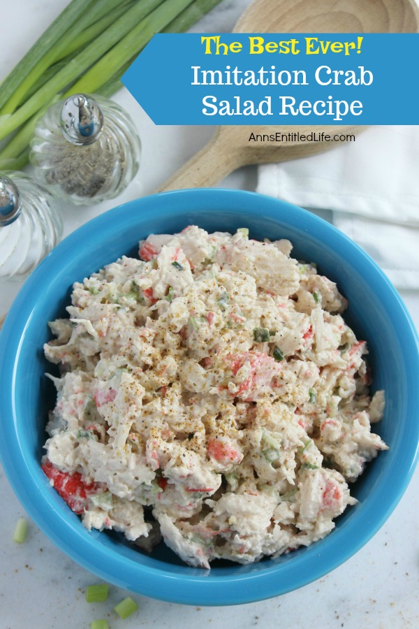 a blue bowl filled with imitation crab salad on a white placemat. There is a wooden spoon in the upper left, as well as a salt and pepper shaker, and a bunch of green onions.