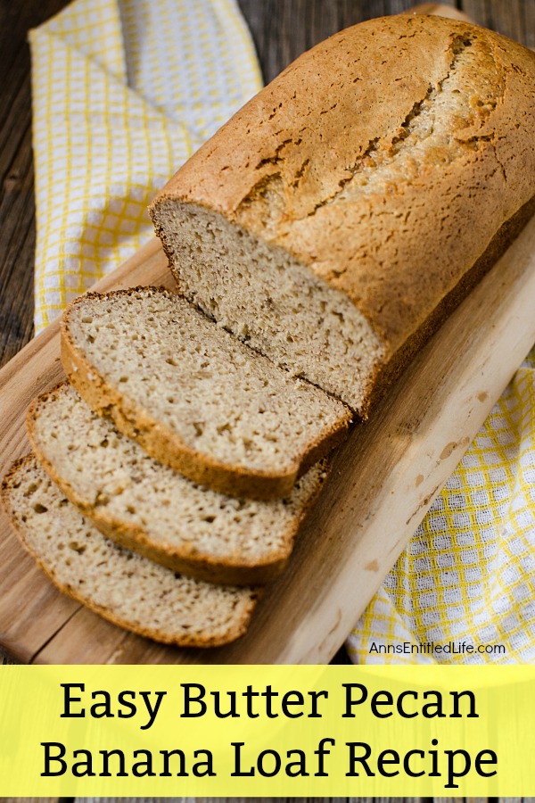 A sliced butter pecan banana loaf on a cutting board, the cutting board is sitting on a yellow and white checked dish towel