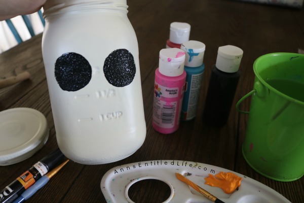 Sugar Skull Mason Jar Craft. This easy to make sugar skull is fashioned from an old Mason jar.  You can store kitchen utensils, candy (keep the lid!), etc in these jar for Halloween or to celebrate the Day of the Dead. Using old glass jars is a great way to get crafty at home and make your own cute décor at the same time.