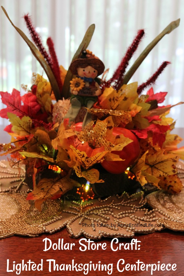 A lighted Thanksgiving centerpiece on a kitchen table, white slider door curtains in the background