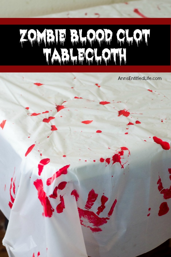 A white tablecloth with red handprints and 