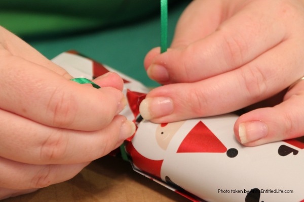 How to Make Christmas Crackers. You can easily make a home version of the popular United Kingdom Christmas Crackers with this step by step tutorial. Great for table favors, decor, and party fun, these Christmas Crackers will delight children and adults at your holiday dinner or party.