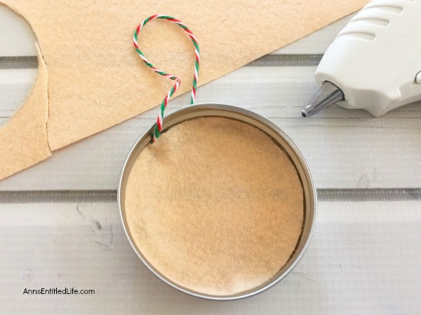 Elf Mason Jar Lid Ornament DIY. This easy to make Elf Mason jar lid ornament is simply adorable. This step by step tutorial has easy to follow directions so you can make one for your tree, to give as a gift, or to place on top of a present as a little something extra.