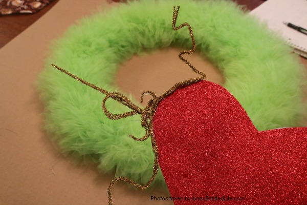 The Grinch Inspired Wreath DIY Tutorial. A beautiful Mr. Grinch inspired wreath sure to make even the coldest heart burst! This step by step tutorial is complete with (free) pdfs for the hat and heart for you to print and make exact. This wreath will look great on your front door, over your mantel, or on a wall. Truly unique holiday decor!