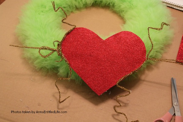 The Grinch Inspired Wreath DIY Tutorial. A beautiful Mr. Grinch inspired wreath sure to make even the coldest heart burst! This step by step tutorial is complete with (free) pdfs for the hat and heart for you to print and make exact. This wreath will look great on your front door, over your mantel, or on a wall. Truly unique holiday decor!