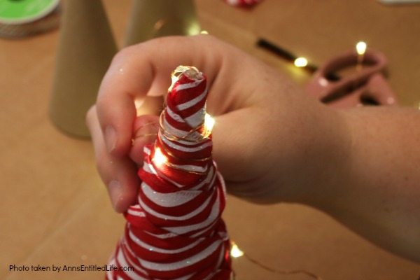 Easy Lighted Ribbon Christmas Tree. This 15 minute craft is simple to make, and highly customizable. This Easy Lighted Ribbon Christmas Tree will dress up your Christmas table, light up your mantel, or just smile as you walk by them. Only you will know how quick and easy these little trees are to put together.