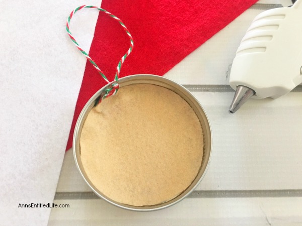 Santa Claus Mason Jar Lid Ornament DIY. Give your Christmas tree a personal touch and make your own ornaments this holiday season. Follow these step-by-step tutorial instructions to make this adorable Santa Claus Mason Jar Lid Ornament!