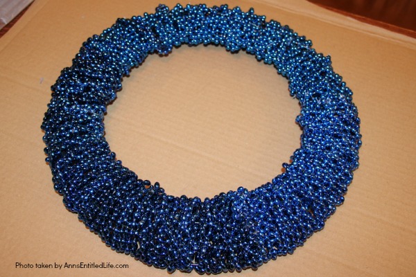 Snowflake Bead Wreath Craft DIY. This is a beautiful snowflake wreath that is perfect for door decor in the chilly winter months. You can fully customize this snowflake bead wreath for color, and ornaments. Simple to make, this lovely Snowflake Bead Wreath Craft is a real conversation piece.
