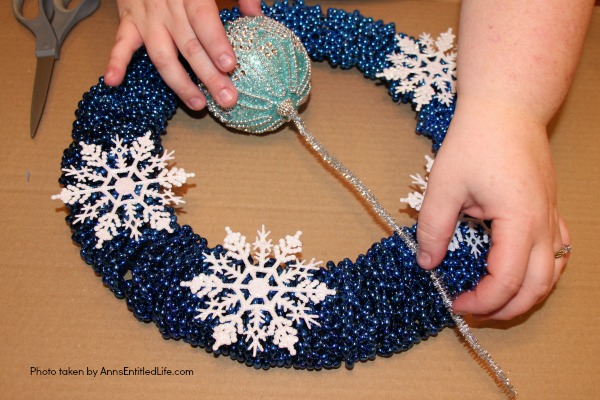 Snowflake Bead Wreath Craft DIY. This is a beautiful snowflake wreath that is perfect for door decor in the chilly winter months. You can fully customize this snowflake bead wreath for color, and ornaments. Simple to make, this lovely Snowflake Bead Wreath Craft is a real conversation piece.