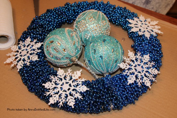Snowflake Bead Wreath Craft DIY. This is a beautiful snowflake wreath that is perfect for door decor in the chilly winter months. You can fully customize this snowflake bead wreath for color, and ornaments. Simple to make, this lovely Snowflake Bead Wreath Craft is a real conversation piece.