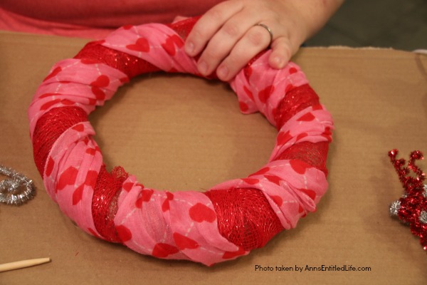 Dollar Store Craft: Heart Wreath. This simple to make heart wreath is made using dollar store finds. It comes together in under 15 minutes, and it a wonderful, inexpensive heart décor. Perfect for Valentine’s Day, Sweetest Day, or any occasion where heart décor is wanted.