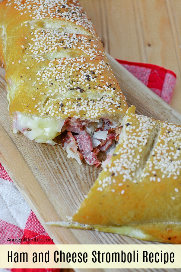 open ham and cheese Stromboli on a wood cutting board