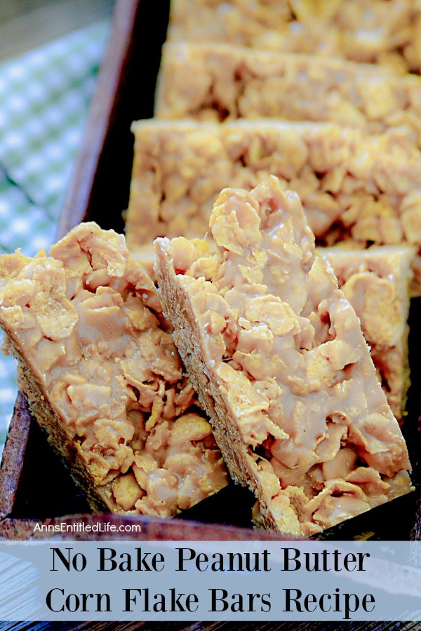 peanut butter bars in a wooden tray on a blue and white checkered kitchen towel