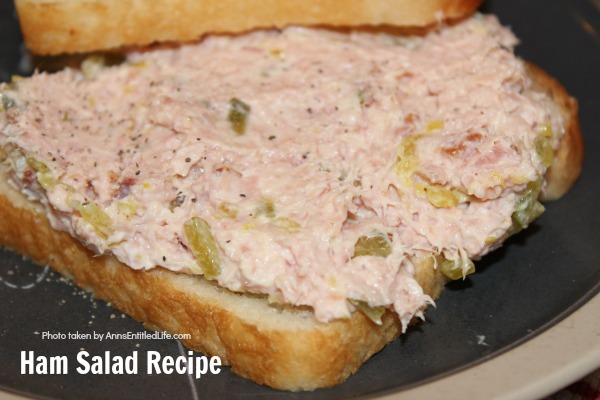 ham salad on white bread on a gray plate on top of red and white dishtowel