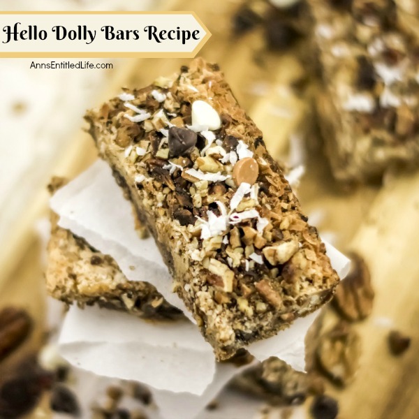 stacked cookie bars on white papers on top of butcher block cutting board