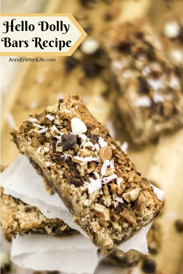 stacked cookie bars on white papers on top of butcher block cutting board