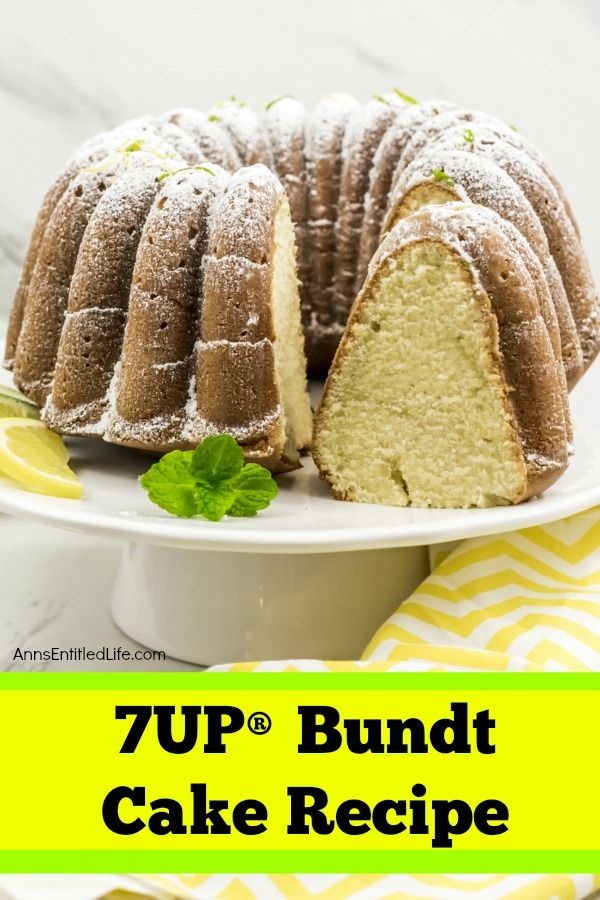 7UP Bundt cake on a white cake dish atop yellow and white chevron linen. There is a piece of the cake cut, and it is turned in profile toward the front.