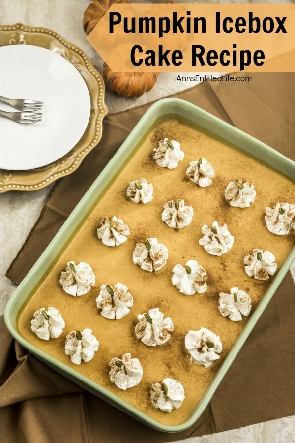 Overhead shot of a pumpkin icebox cake in the pan that is placed upon a brown napkin. There is a placesetting of plates with forks in the upper left.