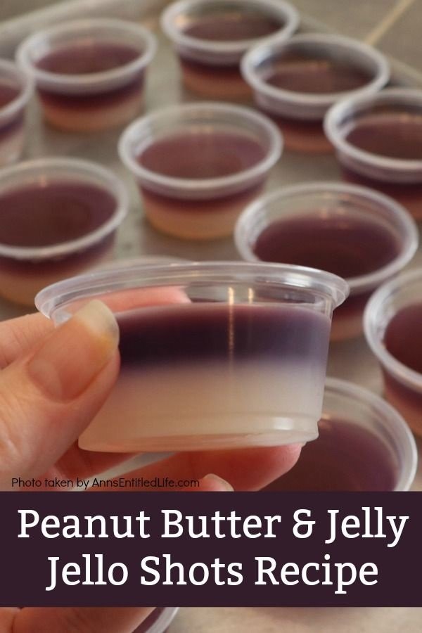 a woman's hand is holding a peanut butter and jelly jello shot, there are multiple shot containers in the background
