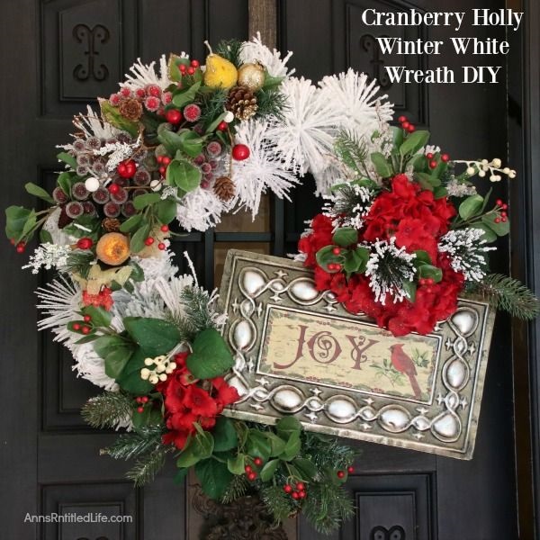 Cranberry Holly Winter White Wreath DIY. This beautiful Cranberry Holly Winter White Wreath is a simple rustic wreath that appears time-consuming, but actually comes together in under 30 minutes! Follow these easy step by step directions to make your own lovely custom Christmas door hanger wreath.