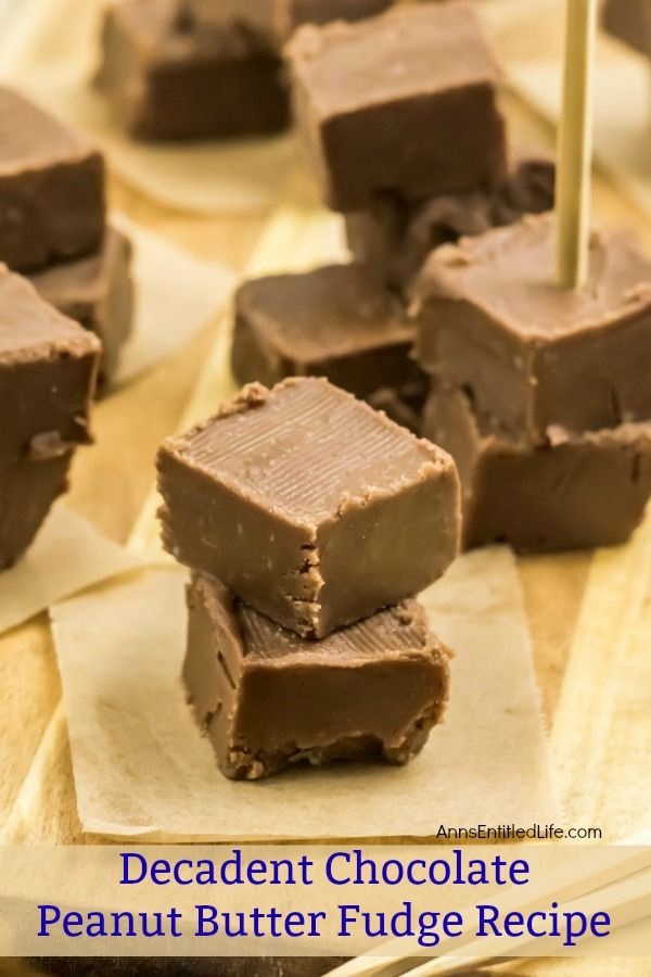 A close up of five piles, two squares high, of chocolate peanut butter fudge. Each pile is on a small brown paper. A pile on the right has a serving pick stuck in it.