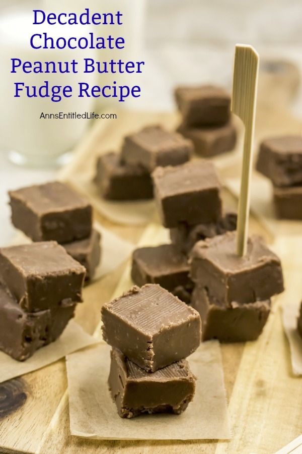 Nine piles, two squares high, of chocolate peanut butter fudge. Each pile is on a small brown paper. A pile on the right has a serving pick stuck in it.