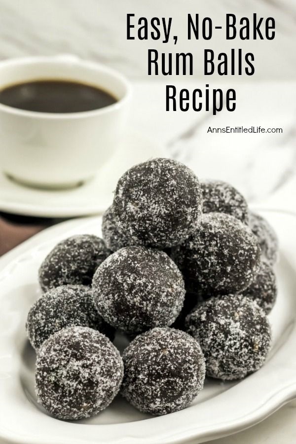 A white plate filled with rum balls. There is a cup of coffee in the background.