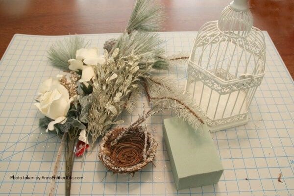 Have an old birdcage lying about that you would like to repurpose into a beautiful decor piece? This wonderful winter white birdcage decorating idea is a lovely DIY decorating piece for the holidays and beyond. This tells the story of a bird that has left the cage to fly south for the winter. His (or her) nest is empty, and he (or she) is off to parts unknown. This is not only a lovely winter piece, it could be used for wedding decor, a centerpiece, a front foyer piece (I always decorate my foyer!) or you could hang it as an empty birdcage in a Florida room or family room.