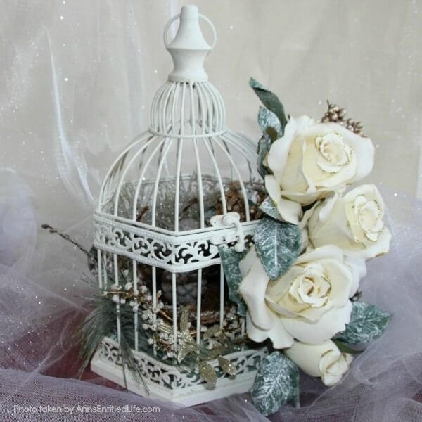 Have an old birdcage lying about that you would like to repurpose into a beautiful decor piece? This wonderful winter white birdcage decorating idea is a lovely DIY decorating piece for the holidays and beyond. This tells the story of a bird that has left the cage to fly south for the winter. His (or her) nest is empty, and he (or she) is off to parts unknown. This is not only a lovely winter piece, it could be used for wedding decor, a centerpiece, a front foyer piece (I always decorate my foyer!) or you could hang it as an empty birdcage in a Florida room or family room.