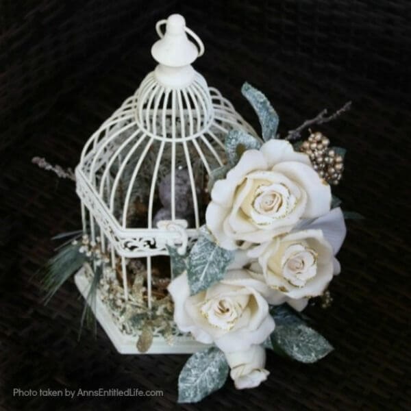 Have an old birdcage lying about that you would like to repurpose into a beautiful decor piece? This wonderful winter white birdcage decorating idea is a lovely DIY decorating piece for the holidays and beyond. This tells the story of a bird that has left the cage to fly south for the winter. His (or her) nest is empty, and he (or she) is off to parts unknown. This is not only a lovely winter piece, it could be used for wedding decor, a centerpiece, a front foyer piece (I always decorate my foyer!) or you could hang it as an empty birdcage in a Florida room or family room.