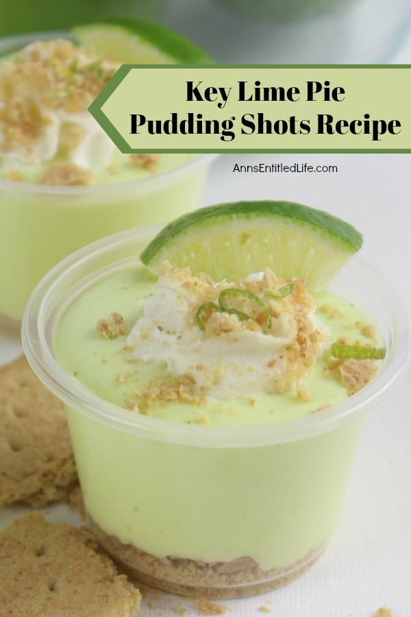 Extreme close up of a key lime pie pudding shot surrounded by broken Graham crackers. A second pudding shots in the background