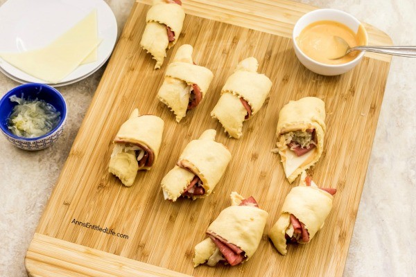 Reuben Crescent Rolls Recipe. These delightful little rolls are a fantastic combination of corned beef, Swiss cheese, sauerkraut, and Thousand Island dressing for a new version of the old favorite deli sandwich. These Reuben crescent rolls are wonderful for serving as an appetizer, snack, or enjoying two or three for your lunch!