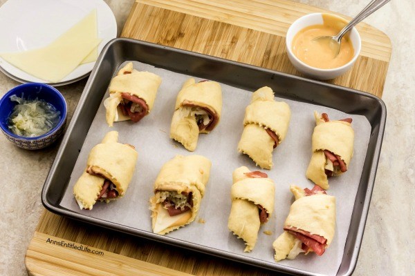 Reuben Crescent Rolls Recipe. These delightful little rolls are a fantastic combination of corned beef, Swiss cheese, sauerkraut, and Thousand Island dressing for a new version of the old favorite deli sandwich. These Reuben crescent rolls are wonderful for serving as an appetizer, snack, or enjoying two or three for your lunch!
