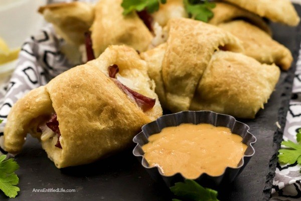 Reuben Crescent Rolls Recipe. These delightful little rolls are a fantastic combination of corned beef, Swiss cheese, sauerkraut, and Thousand Island dressing for a new version of the old favorite deli sandwich. These Reuben crescent rolls are wonderful for serving as an appetizer, snack, or enjoying two or three for your lunch!