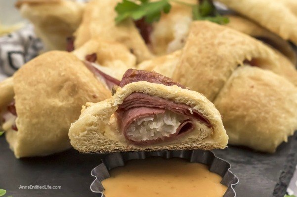 Reuben Crescent Rolls Recipe. These delightful little rolls are a fantastic combination of corned beef, Swiss cheese, sauerkraut, and Thousand Island dressing for a new version of the old favorite deli sandwich. These Reuben crescent rolls are wonderful for serving as an appetizer, snack, or enjoying two or three for your lunch!